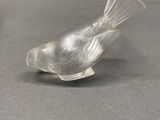 un oiseau en verre posé sur une table