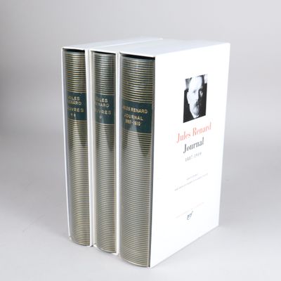 three books are stacked on top of each other on a white surface