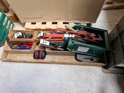 de nombreux outils différents dans une boîte posée par terre