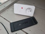 a remote control sitting on the floor next to a power strip
