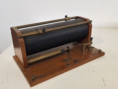 un appareil ancien en bois et en métal posé sur une surface blanche