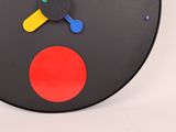 a black clock with a red circle on the face