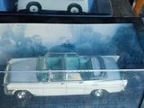 une petite voiture blanche dans une vitrine posée sur une table