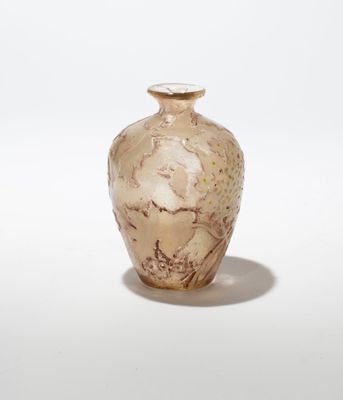 un petit vase posé sur une surface blanche