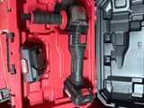 une boîte à outils rouge contenant un marteau et une perceuse