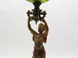 une statue représentant une femme tenant un vase en verre vert