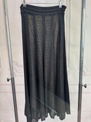 black skirt hanging on a rack in a room with white walls