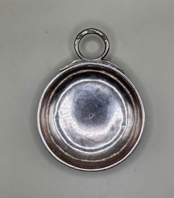 an old silver plate with a ring hanging from it ' s side