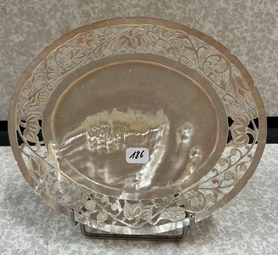 une photo d'une assiette en argent posée sur un support, sur laquelle est fixée une étiquette avec un nom