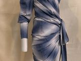 un mannequin portant une robe bleue et blanche, posé sur un présentoir à mannequins