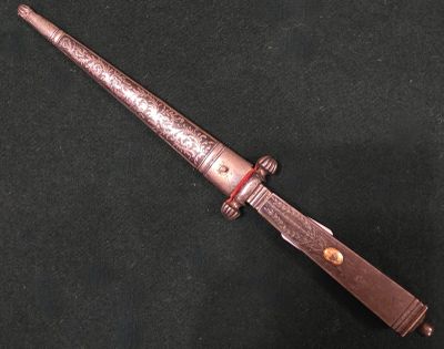 un vieux couteau avec un manche en bois posé sur une surface noire