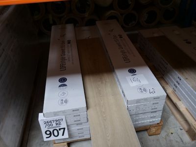Plusieurs caisses en bois sont empilées sur des palettes dans un entrepôt