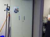a room with a door and a trash can in it