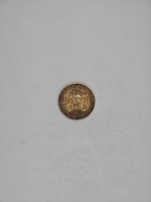 a gold coin sitting on top of a white surface