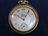 an old pocket watch sitting on top of a black cloth