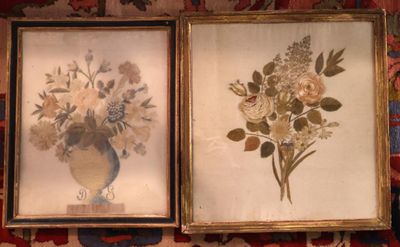 deux photos encadrées représentant des fleurs dans un vase posées sur un tapis