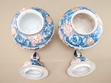 two blue and white vases sitting on top of a table next to each other
