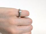 la main d'une femme tenant une bague sertie d'un diamant
