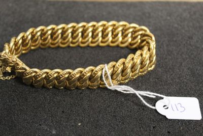 a close up of a gold bracelet with a tag on it