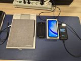 Plusieurs téléphones portables sont posés sur une table, à côté d'un chargeur.