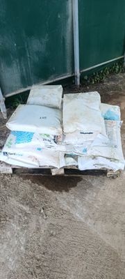 un tas de matelas posé par terre près d'une clôture