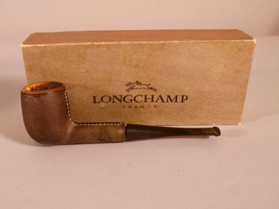 une photo d'une pipe Longchamp posée devant une boîte