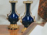 two blue vases sitting on a table next to an open book