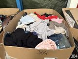 a cardboard box full of clothes sitting on the floor
