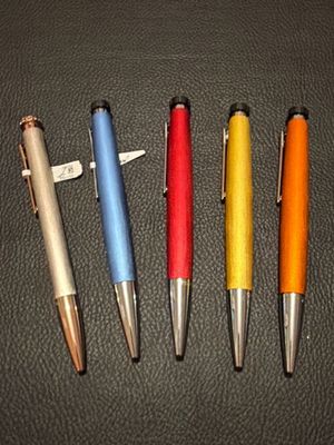 four pens are lined up in a row on a black surface