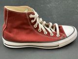 a close up of a pair of red converses on a table