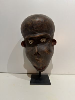 sculpture of a man ' s head on a stand in front of a white wall