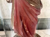 a statue of jesus holding a cross in a glass dome