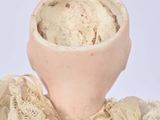 a small doll with a bowl of ice cream in it