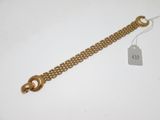 Gros plan sur un bracelet en chaîne en or portant une étiquette