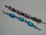 une paire de bracelets en perles de verre bleues et roses sur un fond blanc