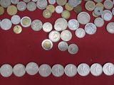 a lot of coins that are on a red table