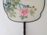 a fan with a painting of a bird and flowers on it