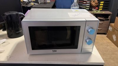 a white microwave sitting on top of a white counter
