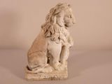a stone statue of a lion sitting on a stone block