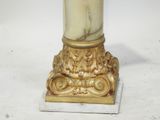 a white and gold vase on a marble base