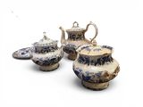 three pieces of blue and white pottery sitting on a white surface