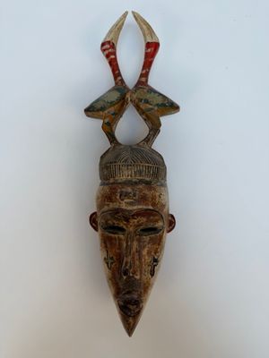 une image d'un masque en bois accroché au mur