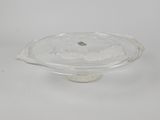 une photo d'un plat à gâteau en verre transparent posé sur une surface blanche