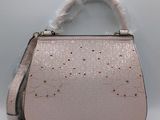 le petit sac à main rose est posé sur une surface blanche
