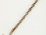 a close up of a gold chain with a cross on it
