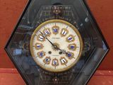 une horloge posée sur une table, à l'intérieur d'une vitrine