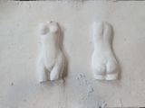 deux sculptures représentant une femme et un homme, fixées au mur