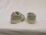 green veja shoes with white soles on a white surface