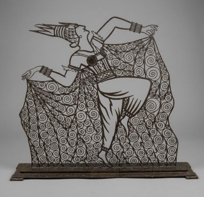 an image of a metal sculpture of a man and a woman on a rock