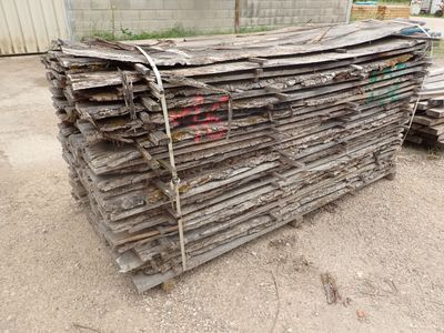 un tas de bois posé par terre devant un bâtiment